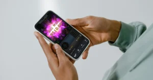 Close-up of a person's hands holding a smartphone displaying a big win in one of the best rated online slots