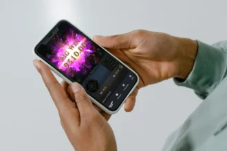 Close-up of a person's hands holding a smartphone displaying a big win in one of the best rated online slots