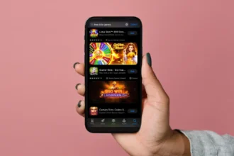 Hand holding a smartphone displaying a selection of the best free slot games for Android on a mobile app store.